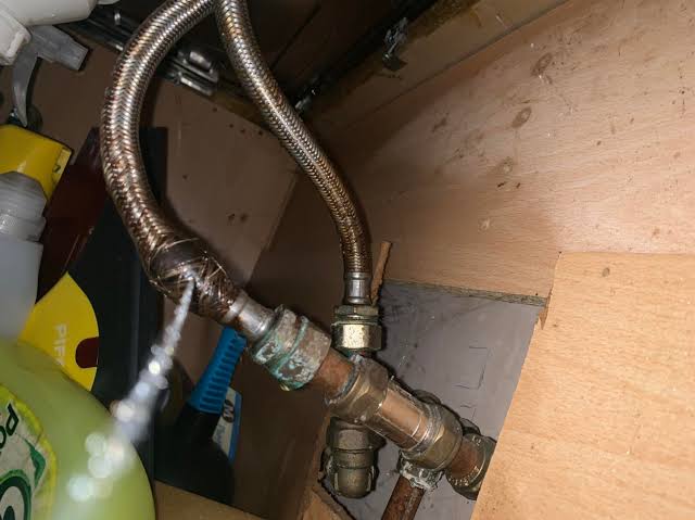 Photo: leaking braided supply line spraying under sink